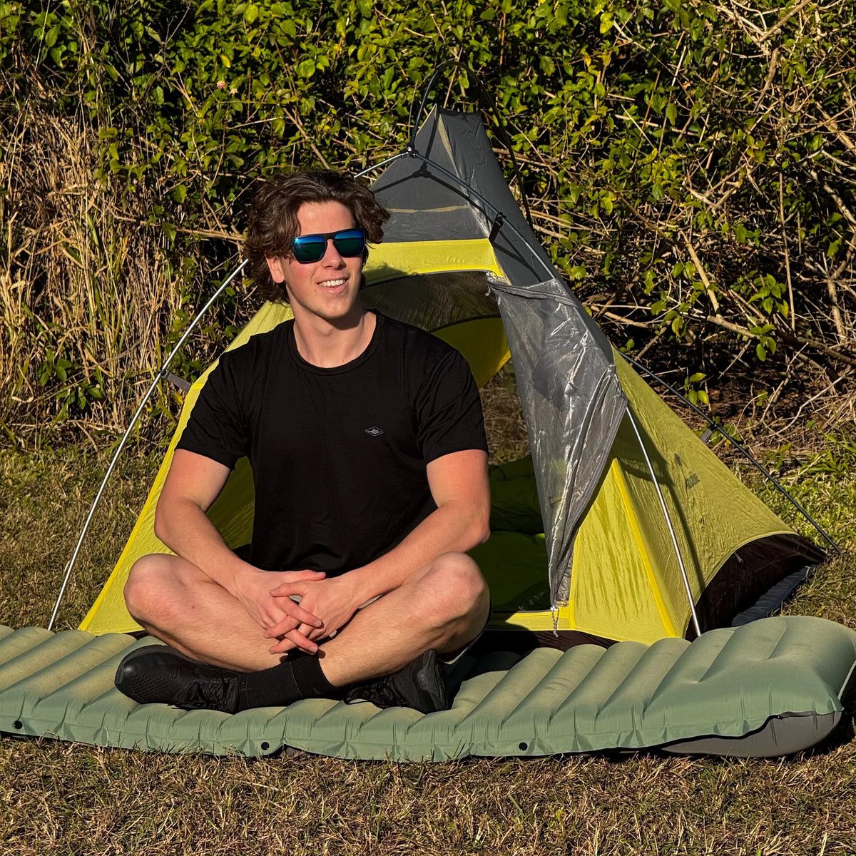 Homme assis devant sa tente sur le Matelas ultraléger Florelya™ Pro